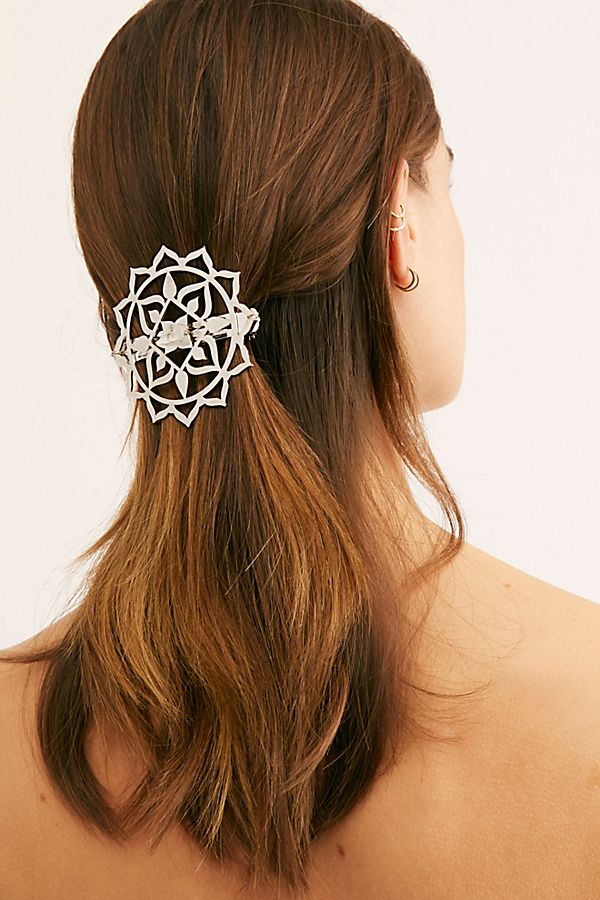 Jeweled barrettes pinned at the side of a low vintage updo